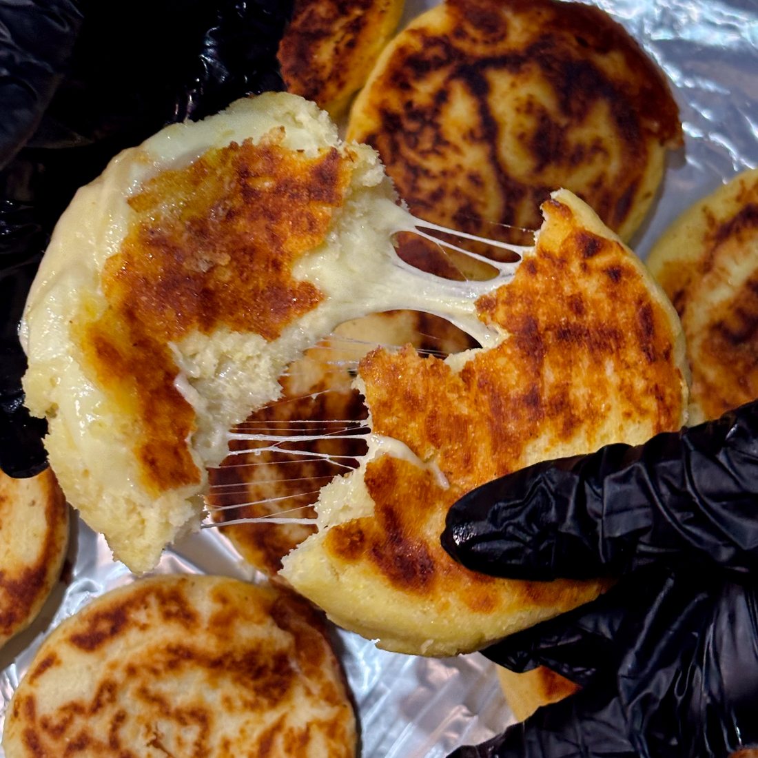 Arepa abierta con el queso derretido estirándose